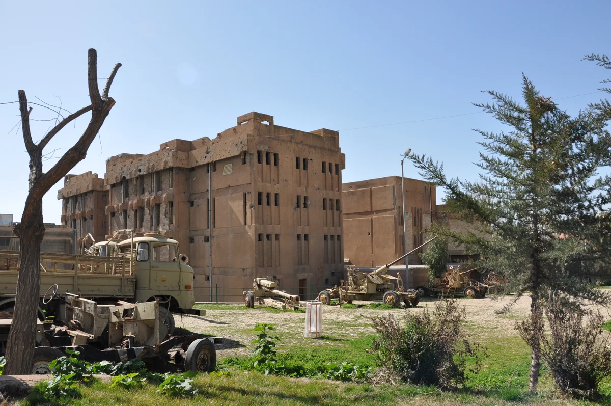 Exterior view of the Amna Suraka tower with captured military equipment in the yard
